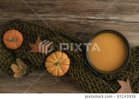 bowl of pumpkin soup on the wooden table decorated with winter squash and autumn leaves bowl of pumpkin soup on the wooden table decorated with winter squash and autumn leaves 83143916