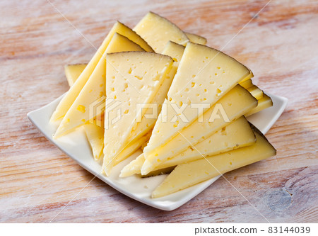 Slices of semi-hard cheese Slices of semi-hard cheese 83144039