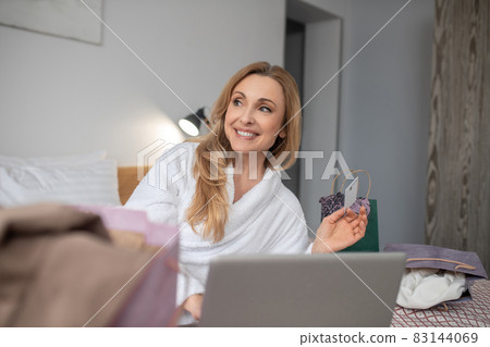 Woman with credit card and dreaming look Woman with credit card and dreaming look 83144069