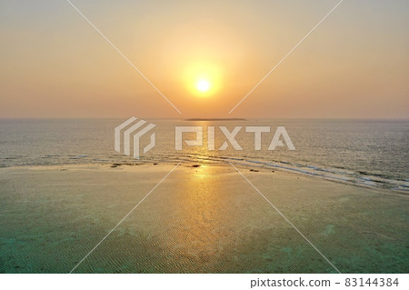 Aerial view of the setting sun and sunset over the sea of Okinawa with a drone (Minna Island) 83144384