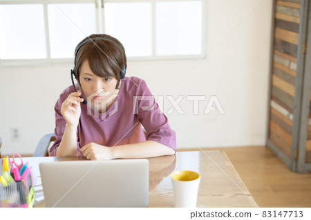 A young woman with a surprised look at a ZOOM video conference during teleworking A young woman with a surprised look at a ZOOM video conference during teleworking 83147713
