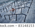 Top view of young athletic woman running upstairs fast, training at urban city stadium 83148153