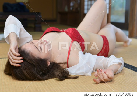 穿著紅色內衣躺在榻榻米上的年輕女子 83149392