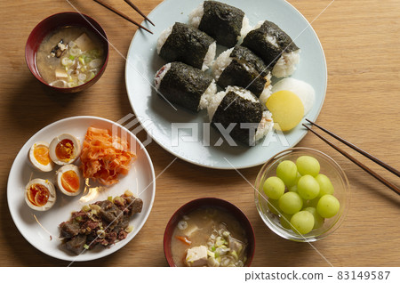 Side dishes such as rice balls, boiled eggs, carottes rape, corned beef 83149587