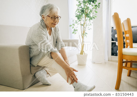 Elderly woman with ankle pain 83150443