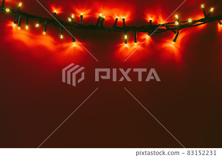 Red background with illuminated lights of garland 83152231