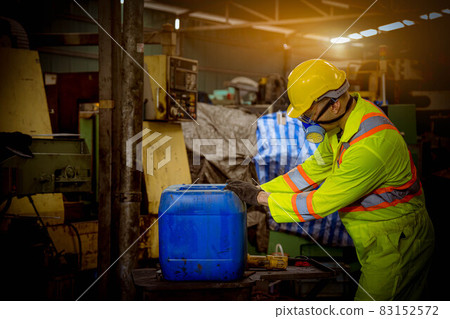 Engineer industry wearing safety uniform ,black gloves ,gas mask feel suffocate when under checking chemical tank in industry factory work. 83152572