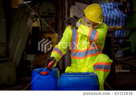 Engineer industry wearing safety uniform ,black gloves ,gas mask feel suffocate when under checking chemical tank in industry factory work. 83152616