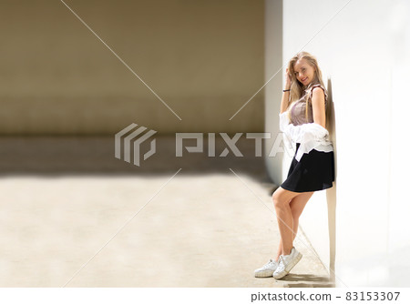 Portrait of young beautiful woman blonde hair standing against wall with copy space Portrait of young beautiful woman blonde hair standing against wall with copy space 83153307