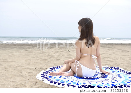 一位身著白色比基尼的年輕女子在 Kujukuri 海岸擺姿勢的背影 83153358