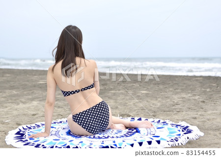 A young woman in a bikini relaxing on the coast of Kujukuri A young woman in a bikini relaxing on the coast of Kujukuri 83154455