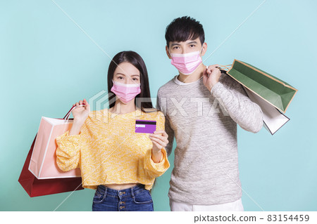 Young couple mask shopping bags credit cards 83154459
