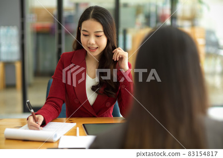 Two beautiful businesswomen discuss a new project, consult on business issues Two beautiful businesswomen discuss a new project, consult on business issues 83154817