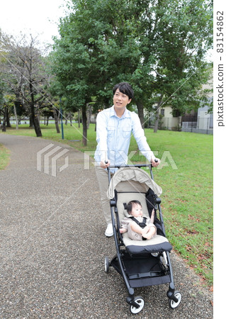 爸爸帶著一個 0 歲的嬰兒在嬰兒車裡散步 爸爸帶著一個 0 歲的嬰兒在嬰兒車裡散步 83154862
