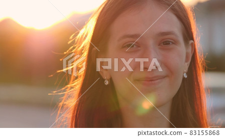 Young happy girl walks down the street smiling at sunset in the city, be satisfied with life, free woman walks in the park, walking, slow motion, student goes to study at dawn at the institute Young happy girl walks down the street smiling at sunset in the city, be satisfied with life, free woman walks in the park, walking, slow motion, student goes to study at dawn at the institute 83155868