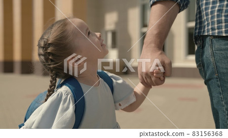 Dad leads the child by hand to school, close-up, a little schoolgirl with backpack, a happy family, a kid's childhood dream, an active student girl, good modern education, love and receive knowledge 83156368