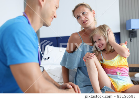 Young doctor communicates with woman little girl 83156595