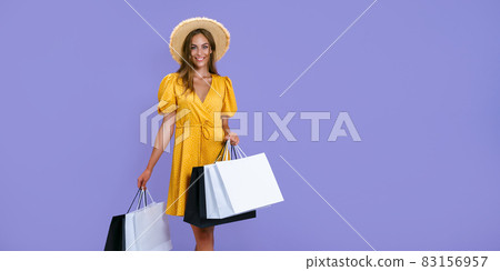 Smiling woman holds shopping bags on purple background. sales, purchases, shopping, Black Friday 83156957