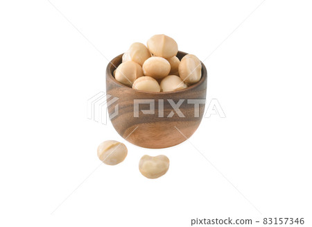 Macadamia nuts in wooden bowl on white background 83157346