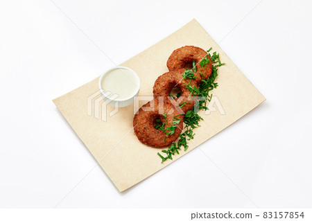 Arabic food inspired cuisine as known as Falafel which is served with hummus sauce besides on a white plate and white background. 83157854
