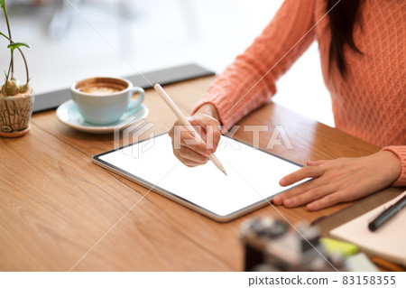 Female freelance graphic designer sketching her graphic digital photo art on modern tablet 83158355