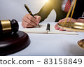 lawyer Detail of a judge sitting at his desk, studying new laws and legislation and taking notes. 83158849