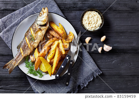 Roasted sea bass on a plate with french fries Roasted sea bass on a plate with french fries 83159459