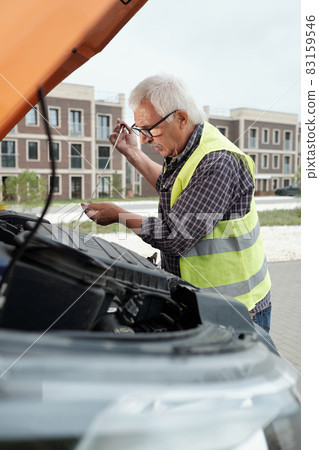 Senior bus driver with handtool checking motor Senior bus driver with handtool checking motor 83159546