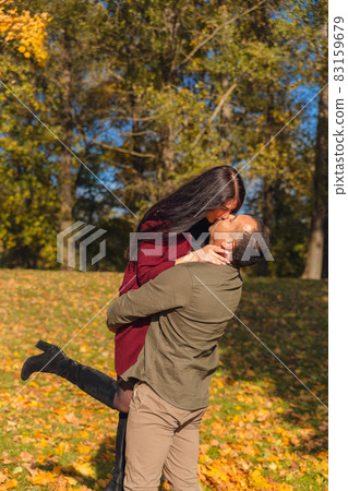 Lovely couple having fun together in nature. Boyfriend carrying his girlfriend in his arms. Lovely couple having fun together in nature. Boyfriend carrying his girlfriend in his arms. 83159679
