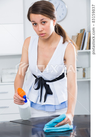 Woman 20s years old is cleaning dust from the table Woman 20s years old is cleaning dust from the table 83159837