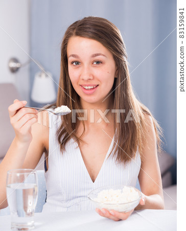 Young woman is enjoying tasty curd Young woman is enjoying tasty curd 83159841