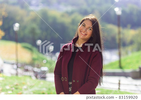 Portrait of a joyful young woman enjoying in the autumn park. Portrait of a joyful young woman enjoying in the autumn park. 83159920