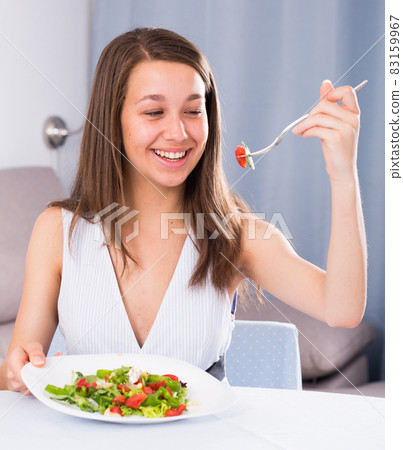 Woman is enjoying tasty green salad Woman is enjoying tasty green salad 83159967