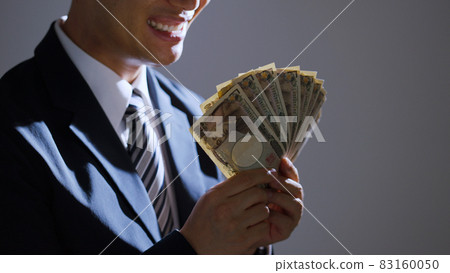 Middle-aged businessman looking at money (business / finance) Middle-aged businessman looking at money (business / finance) 83160050