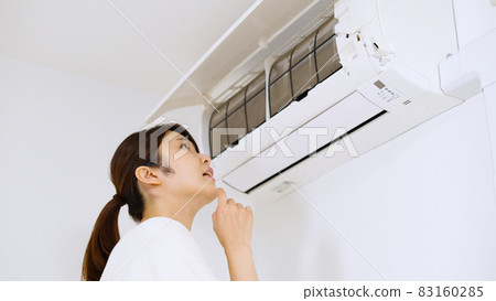 一位女士正在檢查空調過濾器。 一位女士正在檢查空調過濾器。 83160285