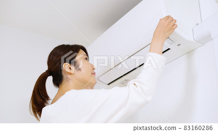 一位女士正在檢查空調過濾器。 一位女士正在檢查空調過濾器。 83160286