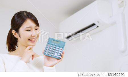 A woman thinking about the electricity bill of an air conditioner .. 83160291