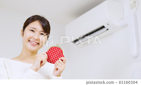 A woman thinking about the electricity bill of an air conditioner .. 83160304