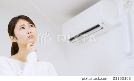 A woman thinking about air conditioning. 83160308