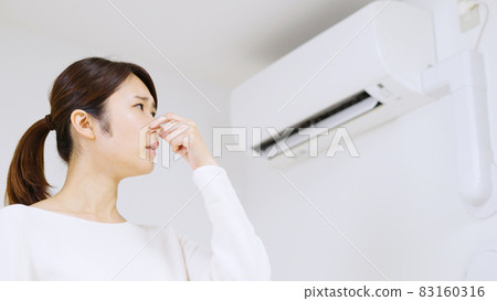 一個擔心空調上有灰塵和黴菌氣味的女人.. 83160316