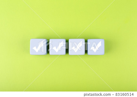 Four checkmarks on white cubes against bright green background Four checkmarks on white cubes against bright green background 83160514