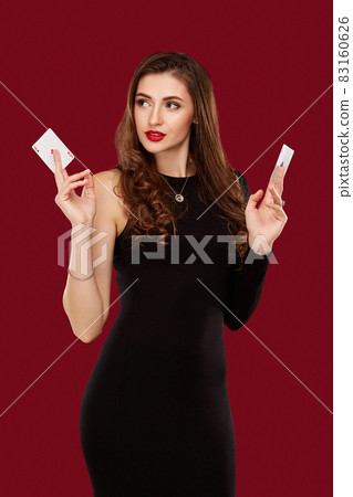 Beautiful caucasian woman in black dress with poker cards gambling in casino Beautiful caucasian woman in black dress with poker cards gambling in casino 83160626