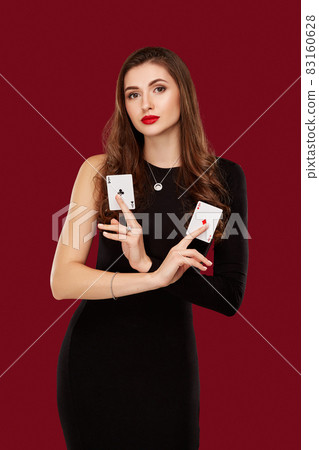 Beautiful caucasian woman in black dress with poker cards gambling in casino Beautiful caucasian woman in black dress with poker cards gambling in casino 83160628
