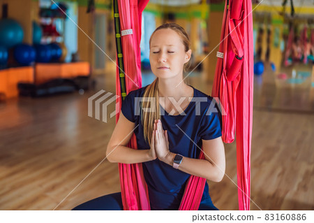 Young beautiful woman practicing aerial yoga in gym. Lifestyle 83160886