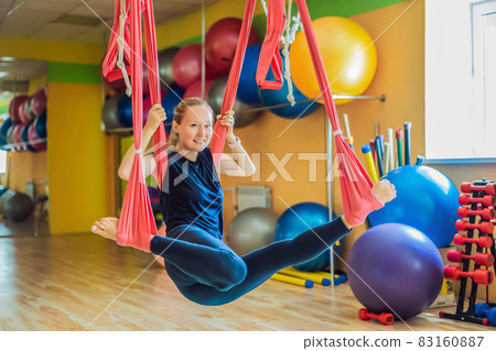 Young beautiful woman practicing aerial yoga in gym. Lifestyle 83160887