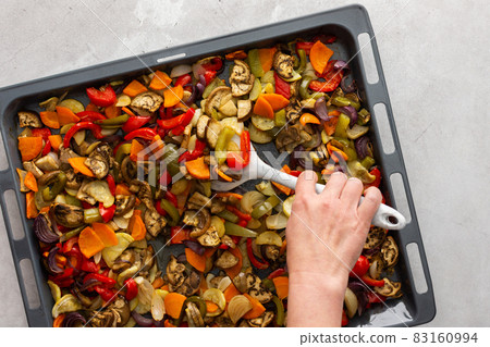 Woman stirring stewed vegetables with a silicone spatula Woman stirring stewed vegetables with a silicone spatula 83160994