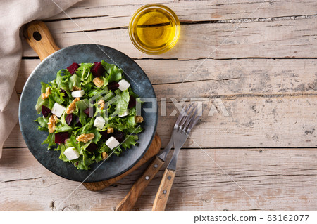 Beetroot salad with feta cheese,lettuce and walnuts on wooden table Beetroot salad with feta cheese,lettuce and walnuts on wooden table 83162077