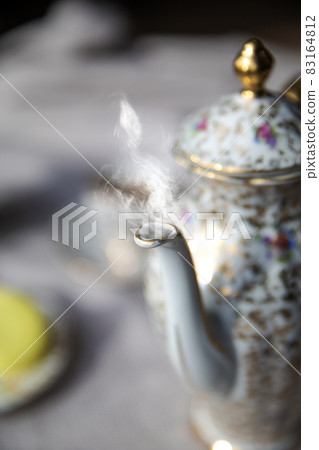 Traditional antique tea pot English culture afternoon tea with hot tea and smoke on diner table, vintage high tea concept elegant stylish set Traditional antique tea pot English culture afternoon tea with hot tea and smoke on diner table, vintage high tea concept elegant stylish set 83164812