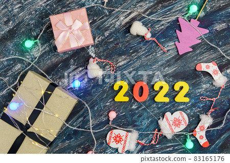 Gift boxes and Christmas decorations 2022 new year on black background. Top view Gift boxes and Christmas decorations 2022 new year on black background. Top view 83165176