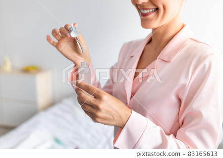 Cropped close up of woman holding bottle of serum 83165613